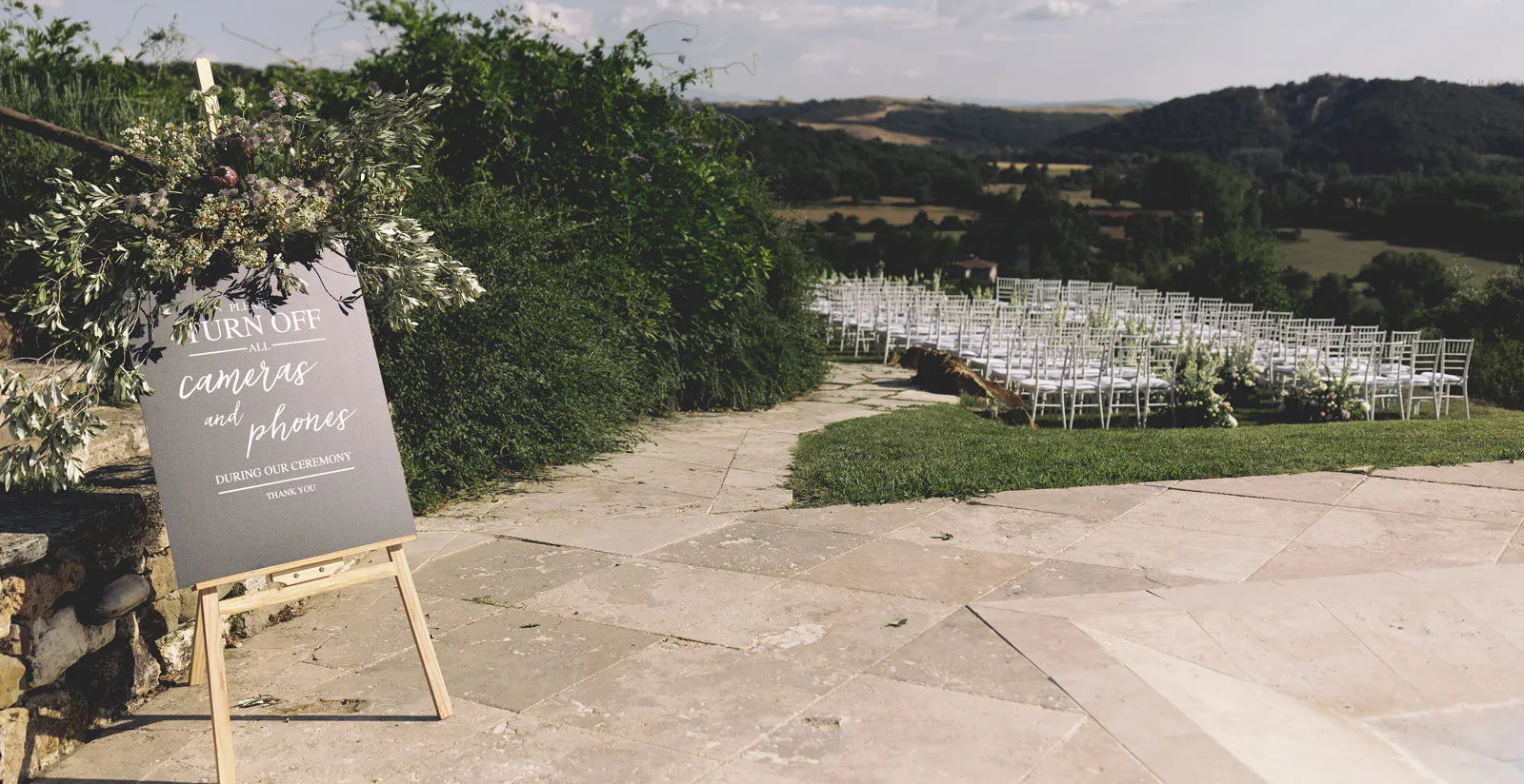 An outdoor ceremony set up on the borgo's terrace above the valley